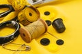 Old retro sewing accessories lie on a yellow fabric. Needle and thread Royalty Free Stock Photo