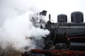 an old retro steam locomotive black with red rides and steam comes out of the pipes. for introductory instructions book