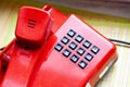Old retro style red landline telephone with black number buttons object detail closeup, communication technology simple concept