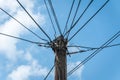 Old retro style wooden pole with many electric supply wires or cables against blue sky Royalty Free Stock Photo