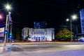 The old and retro theater building and lights lines form fast car on the street at night in the city of Nis, Serbia