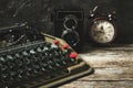 Old retro typewriter, alarm clock and camera on a wooden background