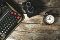 Old retro typewriter, alarm clock and camera on a wooden background top view