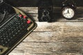 Old retro typewriter, alarm clock and camera on a wooden background top view