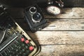 Old retro typewriter, alarm clock and camera on a wooden background top view