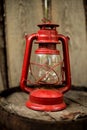 Old retro vinatge style decoration item red kerosene oil lamp on wooden wall background Royalty Free Stock Photo