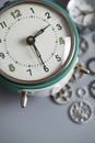 Old retro vintage alarm clock and watch gears on gray table Royalty Free Stock Photo