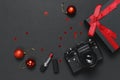 Old retro vintage camera, Black gift box with red ribbon, red lipstick, christmas balls on black background top view flat lay copy Royalty Free Stock Photo