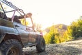 Old retro vintage 4x4 convertible suv vehicle on dirt gravel unpaved road in summer at sunset morning sun. Off road car Royalty Free Stock Photo