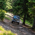 Old retro vintage 4x4 SUV on a dirt gravel dirt road in summer. Off-road car mountain safari adventure nature trip Royalty Free Stock Photo