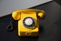 Old Retro Vintage Yellow Rotary Phone on black wood table Royalty Free Stock Photo