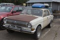 Old retro white GAZ-24 Volga Soviet car with a rusty bonnet parked on a parking lot. Close up corner side view Royalty Free Stock Photo