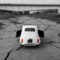 Old retro white toy car on the dirty cracked road Royalty Free Stock Photo