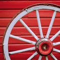 Old Retro Worn Wagon Wheel by Painted Red Wall Royalty Free Stock Photo