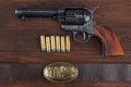 Old revolver with cartridges and U.S. Army soldier& x27;s belt with a buckle