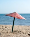 Old rickety shabby beach umbrella by the sea