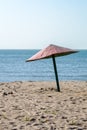 Old rickety shabby beach umbrella by the sea