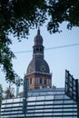 The iconic dome of Riga Cathedral in Riga, Latvia, framed by lush green tree branches. Royalty Free Stock Photo