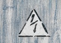 Old risk of electric shock triangle sign on light grey weathered cracked background Royalty Free Stock Photo