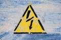 Old risk of electric shock triangle sign on light grey weathered cracked background Royalty Free Stock Photo
