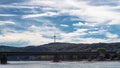 Old road bridge over the river in the background high hills with observation tower, beautiful blue sky with clouds. Royalty Free Stock Photo