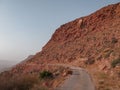 Old road on dry rocky hillside in the desert in vintage sunset light