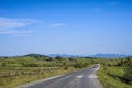 Old road through a field in the mountains on a sunny afternoon Royalty Free Stock Photo