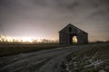 Old road and shed on a cloudy foggy night