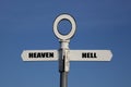 Old road sign with heaven and hell pointing in opposite directions