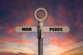 Old road sign with war and peace pointing in opposite directions. Royalty Free Stock Photo