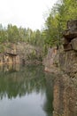 Old rock quarry filled with water surrounded by trees. Royalty Free Stock Photo