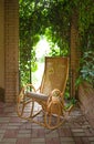 Old rocking chair in the gazebo Red horse eating green grass on a field near by house and trees outdoors in the summer countryside Royalty Free Stock Photo