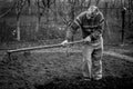 Old romanian man working his land in a traditional way with empty hands, black and white picture Royalty Free Stock Photo