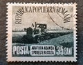 old Romanian stamp from 1953 with the image of a plowing tractor