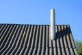 Old roof asbestos roof slates and chimney against blue sky Royalty Free Stock Photo