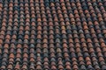 An old roof tiles pattern. Dark red weathered and aged tiles covering roof of old european house Royalty Free Stock Photo