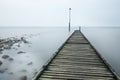 Old Rotted Jetty With Rocks And Sea Mist.