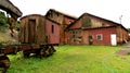 Old rotten and rusty abandoned waggon standing next to an abandoned shed Royalty Free Stock Photo