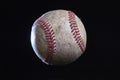 Old rough baseball with dramatic lighting isolated on black background Royalty Free Stock Photo