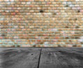 Old rough black wooden table with brown orange brick wall