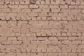 Old rough dirty exterior brick wall texture. Beige shabby messy brickwork. Light brown grunge background Royalty Free Stock Photo