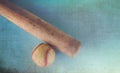 Old rough and rugged baseball and vintage wooden bat on blue texture background.