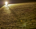 Old rough and uneven brick wall illuminated by a lantern, bottom view Royalty Free Stock Photo