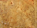 Old rough yellow ochre colored cracked faded stained painted plaster wall texture with red and orange details