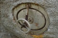 Old round rusty tank faucet close-up outdoors, side view Royalty Free Stock Photo