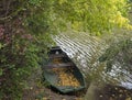 Old rowing boat with fallen leaves on the river Berounka bank in autumn with trees, countryside in golden afternoon Royalty Free Stock Photo