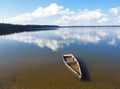 Old rowing boat under water at the shore. The clouds are beautifully reflected in the water. Forsaken broken little craft in a Royalty Free Stock Photo