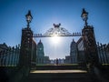 Old Royal Naval College doors entrance near Times river and the sun shining above.