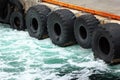 Old rubber tires as fenders on a stone pier