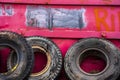 Old Rubber Truck Tires Leaning Against Pink Metal Trash Container in City